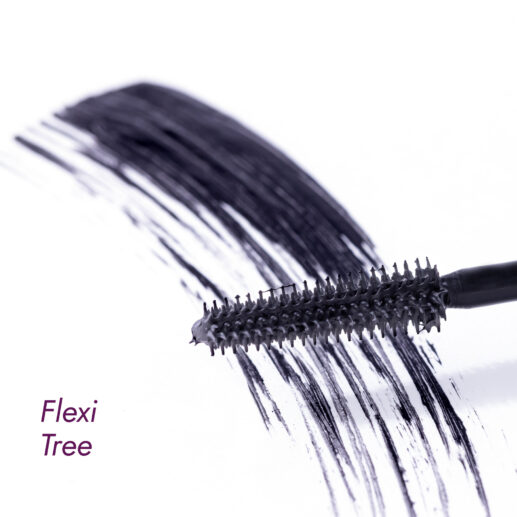 Mascara brush with volumizing mascara strokes on a white surface.