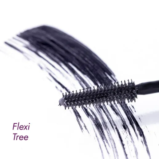 Mascara brush with volumizing mascara strokes on a white surface.