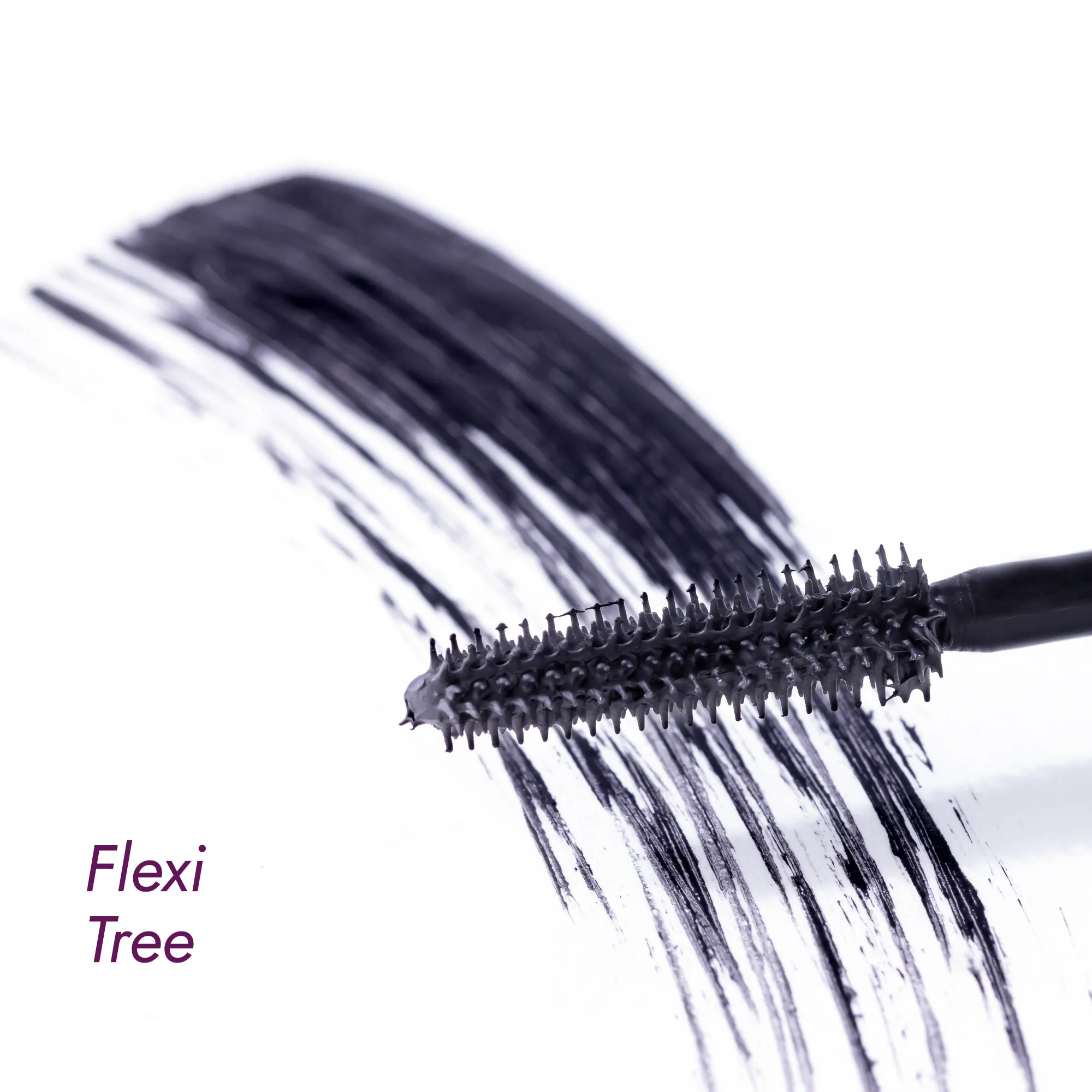 Mascara brush with volumizing mascara strokes on a white surface.