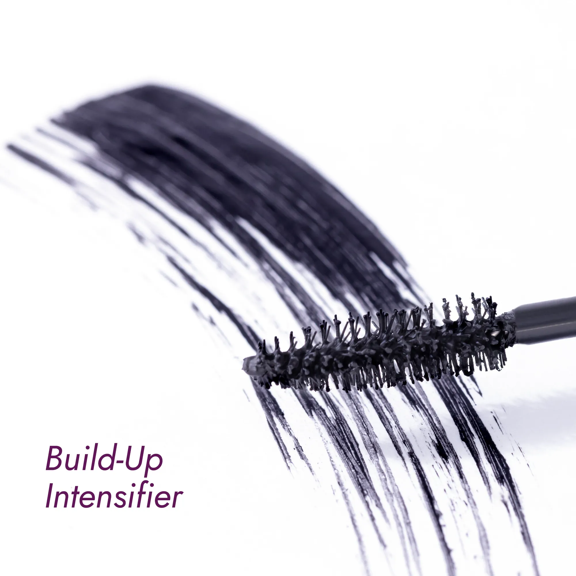 Mascara brush with volumizing mascara strokes on a white surface.