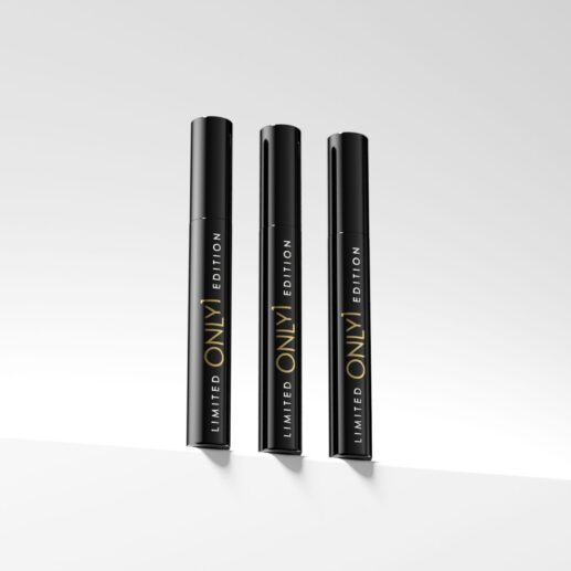 Three limited edition black mascara tubes standing upright on a plain white surface, with a minimalist background.