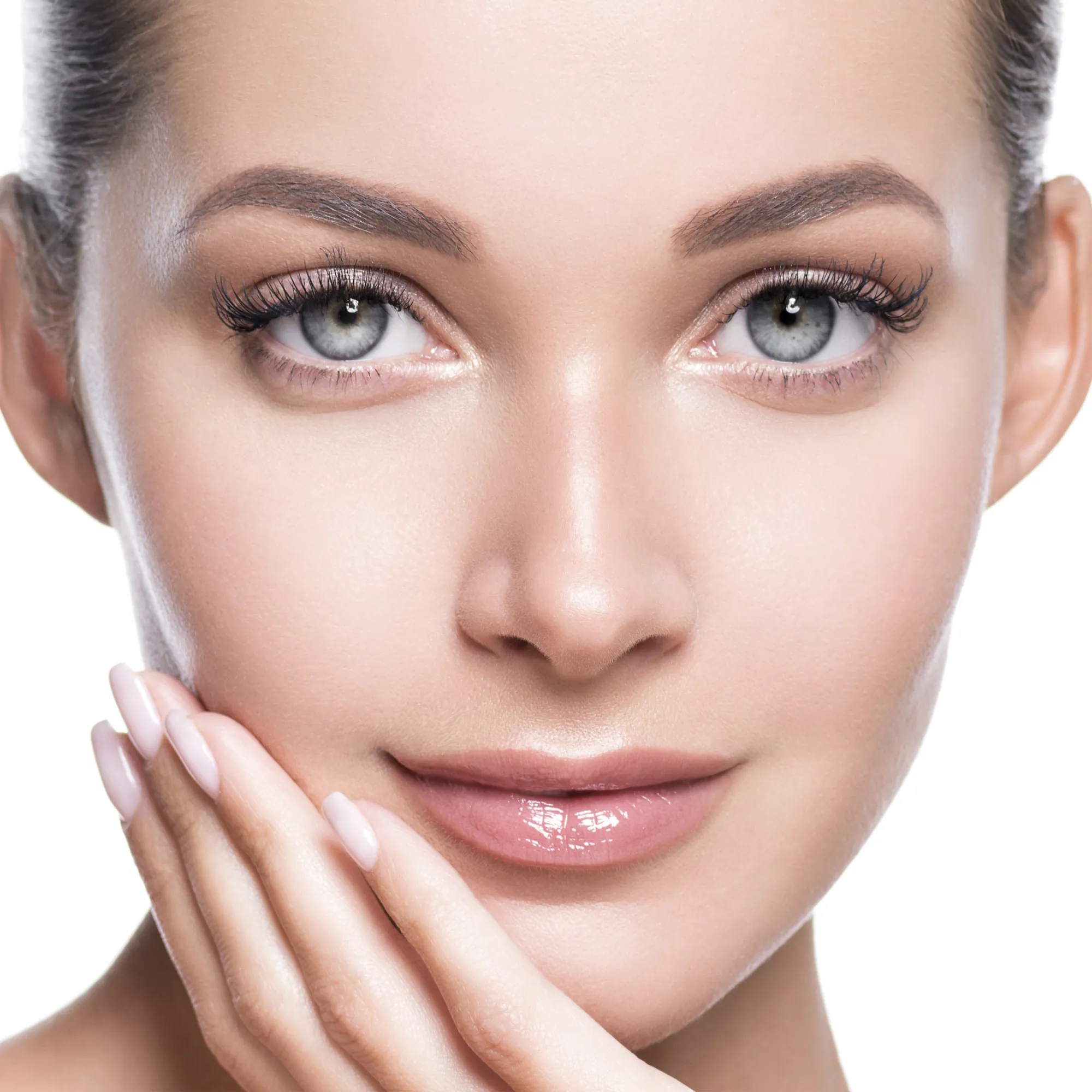 A woman with clear skin, minimal makeup, and manicured nails, gently touching her face.